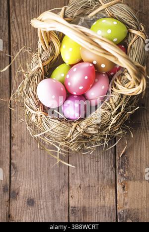 Colorful polka dot eggs in basket with copy space, Easter decorations Stock Photo