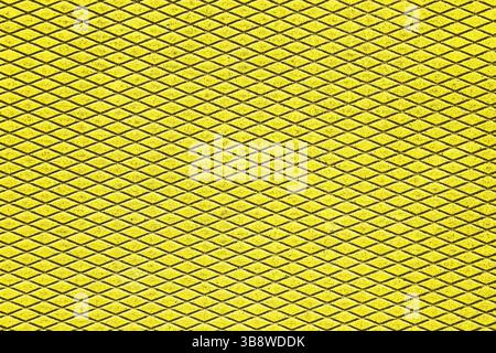 Yellow metal grid mesh background. Diamond-shaped pattern structure. Industrial design element. Repeating geometric surface. Abstract texture. Stock Photo