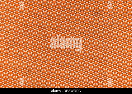 Orange rust grate mesh. Industrial diamond pattern. Weathered metal surface. Safety texture closeup. Rugged grid structure. Grunge abstract background Stock Photo