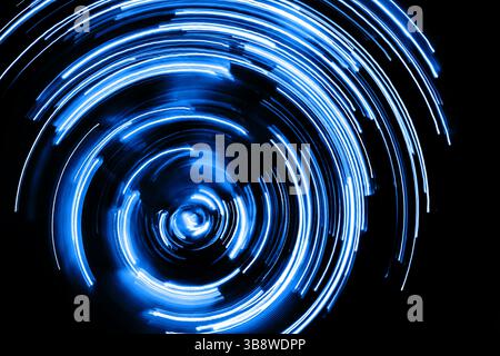 Blue circular light motion. Abstract swirl of glowing energy. Rotating lines with bright center. Futuristic effect. Dynamic movement in spiral design. Stock Photo