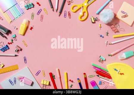 Creative student desk with school supplies and copy space in center. Top view or flat lay. Trendy back to school flat lay on pink background Stock Photo