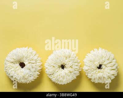 Shag donuts on bright yellow background. Unusual trendy donuts with vanilla buttercream. Copy space. Top view or flat lay Stock Photo