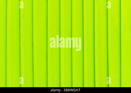 Bright green vertical lines. Neon texture background. Abstract pattern closeup. Vivid color stripes. Minimalism design element. Fluorescent wood vibe. Stock Photo
