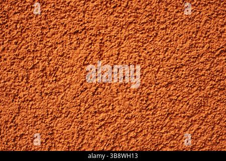 Orange rough wall texture. Stucco facade background. Grunge painted surface. Abstract plaster detail. Coarse pattern on exterior wall. Stock Photo