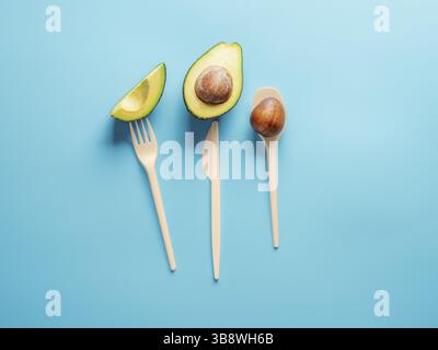 Avocado Seeds Biodegradable Single-Use Cutlery. Bioplastic - Great alternative to plastic disposable cutlery. Minimal concept on blue background Stock Photo