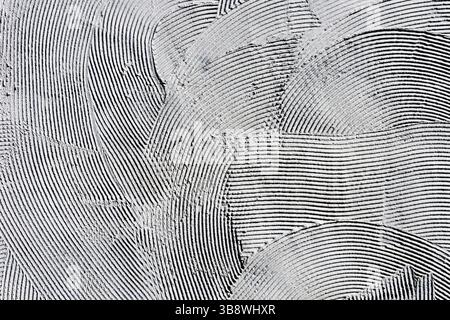 Grunge surface with textured paint pattern. Abstract black and white background. Decorative plaster with curved lines. Artistic scratched effect. Stock Photo