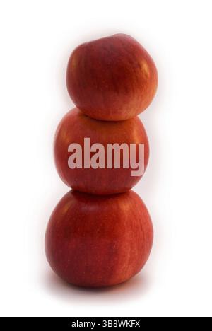 Three red apples stand on each other and shaping ballance isolated on white Stock Photo