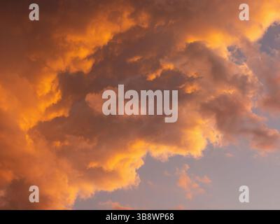 Dramatic sky with clouds. Mysterious abstract background pattern texture. Many yellow and orange tones and patterns of clouds. Stock Photo