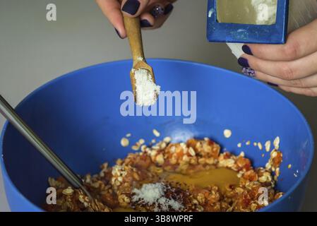 Hand pour in salt from wooden spoons in stuffing Stock Photo