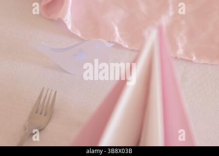 Elegant table setting with pink and white napkins and a bird shaped placeholder, perfect for a romantic wedding reception Stock Photo