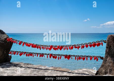 Playa Blanca, Canary Islands. Love locks, heart shaped padlocks attached to old chain railings by visitors on holiday in the Lanzarote resort Stock Photo