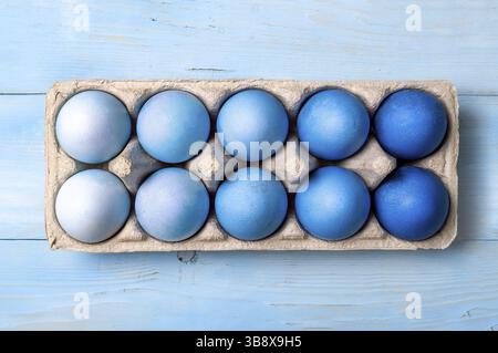 Easter concept. Ombre eggs in blue colors in cardboard packaging on blue wooden background. Top down view or flat lay. Classic blue colors in Easter 2 Stock Photo