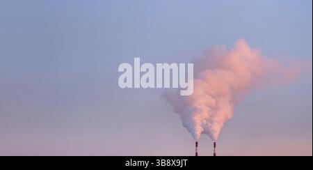 Smoke from chimneys of heating plant. Air pollution. Factory pipes with smoke, frosty weather, sunrise. Ecology problem. Copy space Stock Photo
