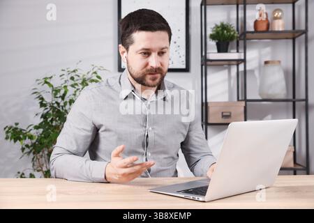 Online speaker streaming with laptop at table indoors Stock Photo