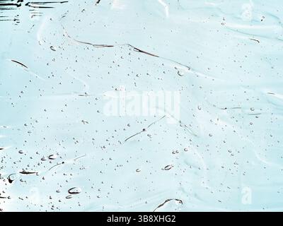 Liquid gel cosmetic texture on blue background. Aesthetic beautiful textured smears transparent skin gel. Top view or flat lay Stock Photo