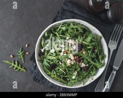 Beetroot, aragula and soft cheese salad over black background. Top view or flat lay. Copy space for text. Idea and recipe for healthy vegetarian salad Stock Photo
