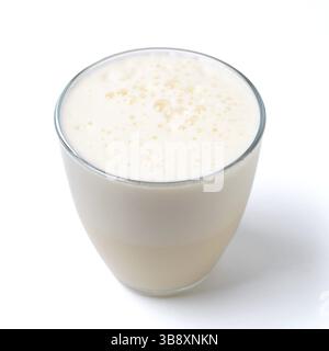 Vanilla milkshake with foam isolated on white. Delicious milk dessert with vanilla in glass isolated on white with clipping path Stock Photo