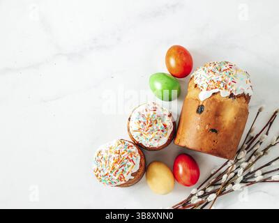 Traditional Russian Ukrainian Easter Cake Kulich. Orthodox Christian Easter Bread or Easter Cake with frosting, Easter Eggs and willow twigs on white Stock Photo
