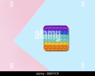 Popit or simple dimple toy on blue and pink background with copy space. Popular silicone colorful antistress pop it toy for child. Top view from above Stock Photo