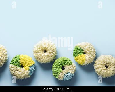 Shag donuts on blue background. Unusual trendy colorful donuts with vanilla buttercream. Copy space. Top view or flat lay Stock Photo