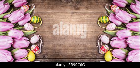 Tulips and eggs border over wooden backdrop. Easter decorations Stock Photo