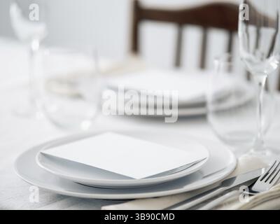 Beautiful table setting in white colors. Empty white plates. Set table for romantic dinner for two at home Stock Photo