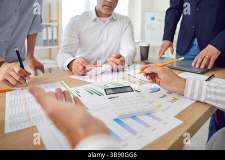 Group of business people counting numbers on a calculator, hands close-up Stock Photo