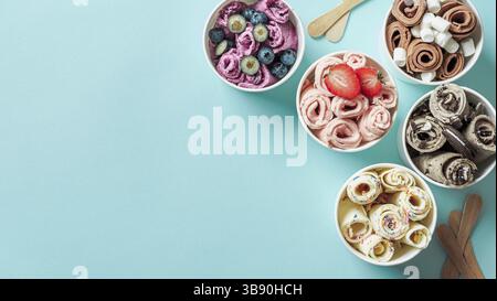 Rolled ice creams in cone cups on blue background. Different iced rolls top view or flat lay. Thai style rolled ice cream with copy space for text or Stock Photo