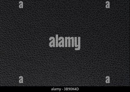 Detailed view of black leather surface showing its unique texture and grain patterns, conveying richness and quality. Stock Photo