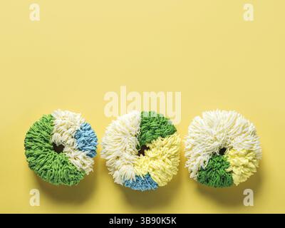 Shag donuts on bright yellow background. Unusual trendy colorful donuts with vanilla buttercream. Copy space. Top view or flat lay Stock Photo