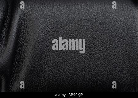 Soft black leather surface displays subtle textures and fine patterns under soft lighting, enhancing its elegance. Stock Photo