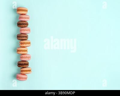 Macarons with copy space. Row of perfect french macarons or macaroons on blue background. Top view or flat lay Stock Photo