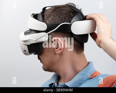 Person wearing virtual reality headset deeply focused on immersive digital environment, showcasing technology. Stock Photo