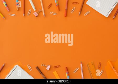Back to school concept, school supplies and accessories on orange background, notebook, pencils, paperclip, duster, flat lay copy space Stock Photo