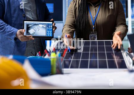 Photovoltaics factory investors evaluating solar panel structure design, addressing technical considerations and innovations for advancing clean energy technology, close up shot Stock Photo