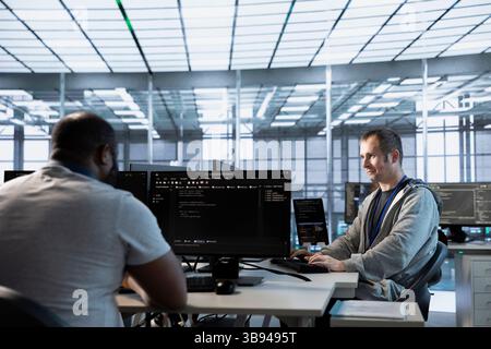 Computer scientists in data center coordinating deployment of server architecture, improving data processing speed. Server farm specialists expert configuring and testing hardware Stock Photo
