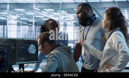 Engineer calling colleagues after finding error in code while doing checkup on server room used for AI workloads. Man requesting help from coworkers after finding bug in data center systems, camera A Stock Photo