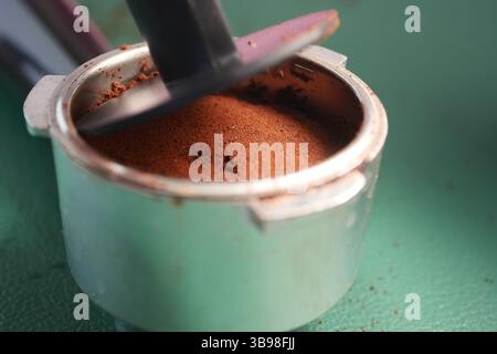 Preparing fresh coffee grounds in a metal coffee filter Stock Photo