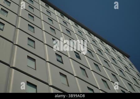 Low angle view, the window pattern on a multi-storey building without balcon. Stock Photo