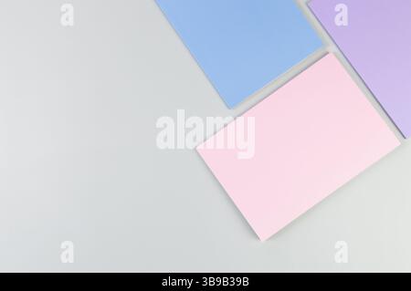 Top view of pink, purple and blue notebooks on grey background. School, office wallpaper. Flat lay, copy space. Stock Photo