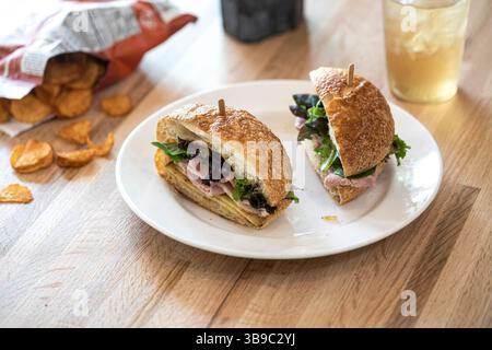 A sandwich bag of chips and drink on wood table Stock Photo