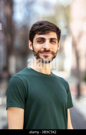head shot of a man with dark hair wearing a green shirt Stock Photo