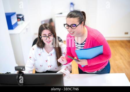 Two Young Women Collaborating on a Computer call Stock Photo