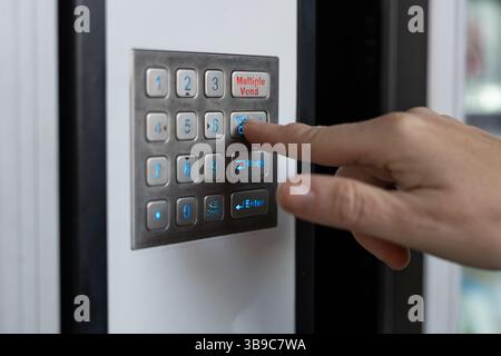 Customer pressing button on vending machine keypad Stock Photo