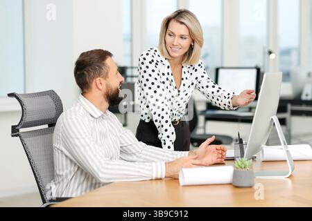 Technicians making digital engineering drawing on computer at desk in office Stock Photo