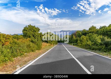 A quiet two-lane road stretches into the distance Stock Photo