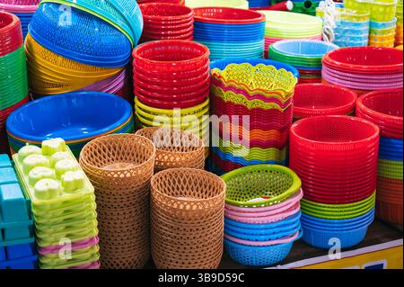 Close-up view of a vibrant stack of plastic bowls and baskets at a market. Stock Photo