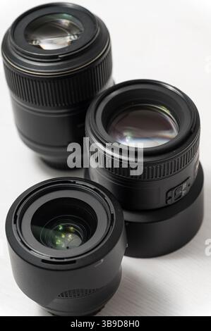 Close-up of three black camera lenses with glass details on white surface, no people, top view, minimalistic composition, modern photographic equipmen Stock Photo
