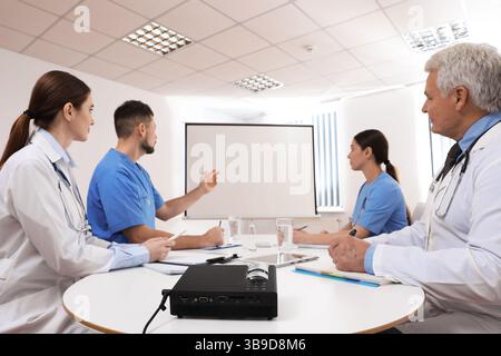 Team of doctors using video projector during conference indoors Stock Photo