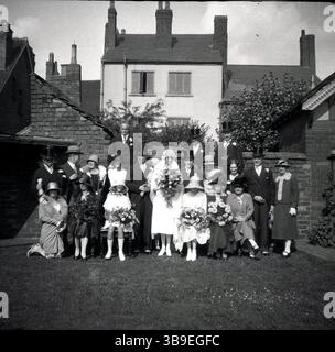 1930s, historical, wedding party outside in a garden, group picture, people dressed in the clothes of the era including for the men several top hats on view, England, UK. Stock Photo